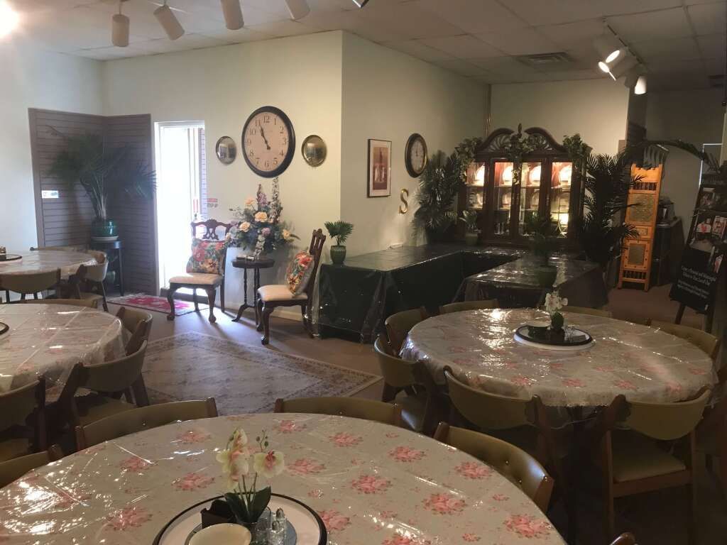 a room with tables and chairs and a clock on the wall .
