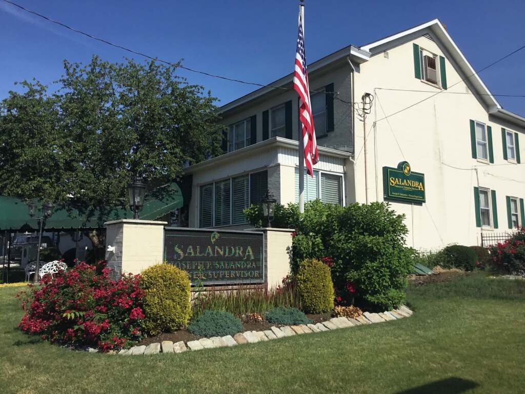 a large white house with a sign in front of it that says salamura