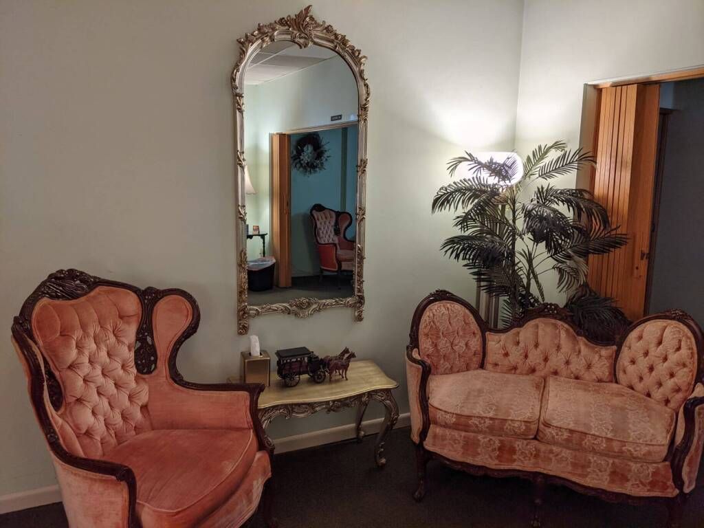 a living room with a couch , chair , and mirror .