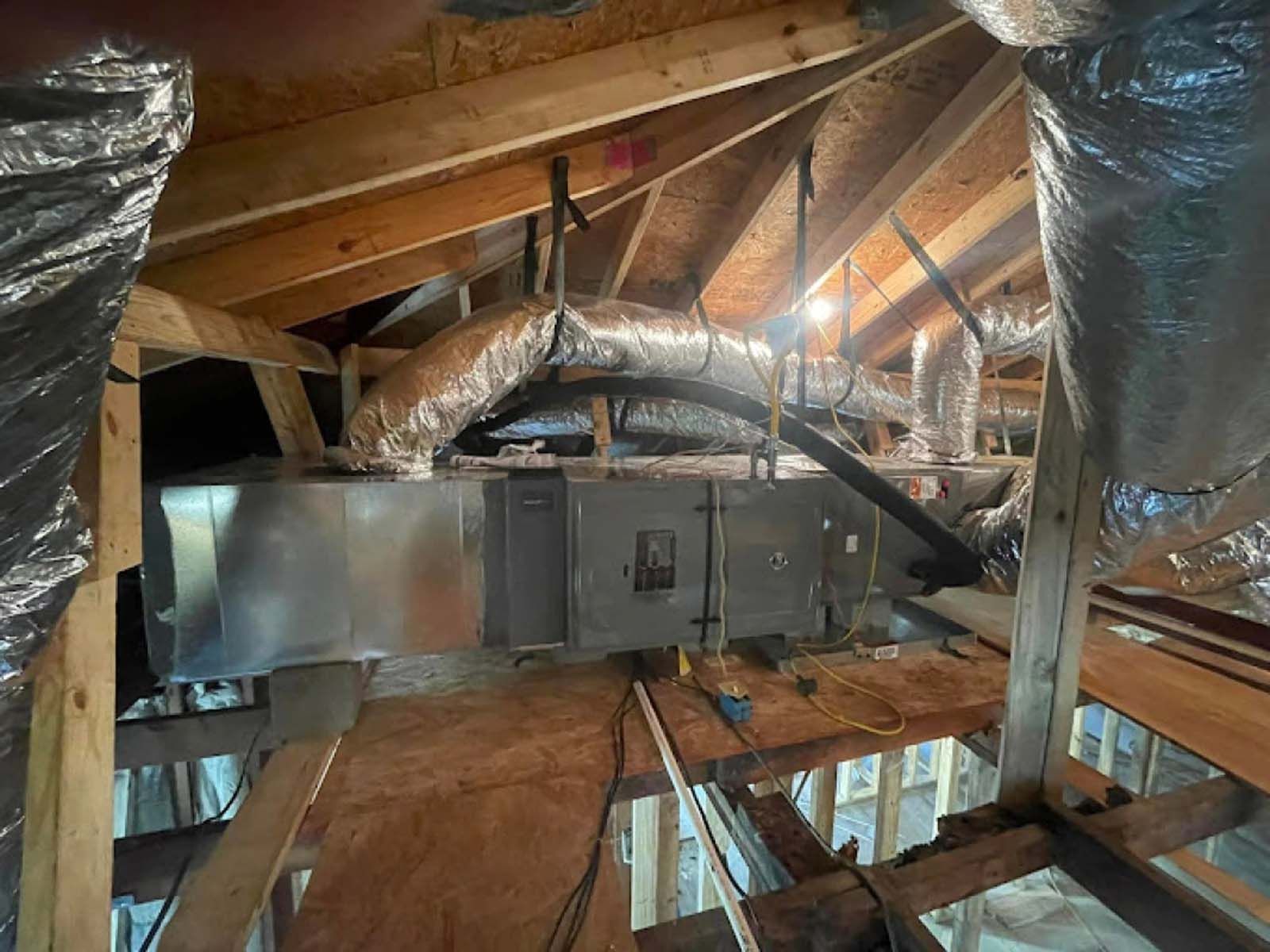 There are a lot of ducts hanging from the ceiling of a building.