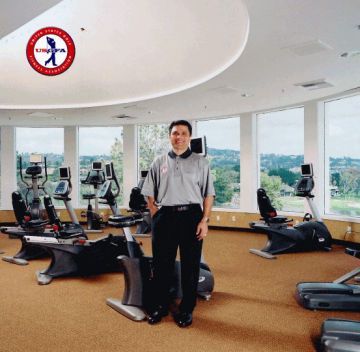 A man is standing in a gym with a sign that says uropa