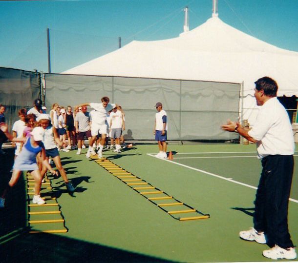 A group of people are playing on a tennis court