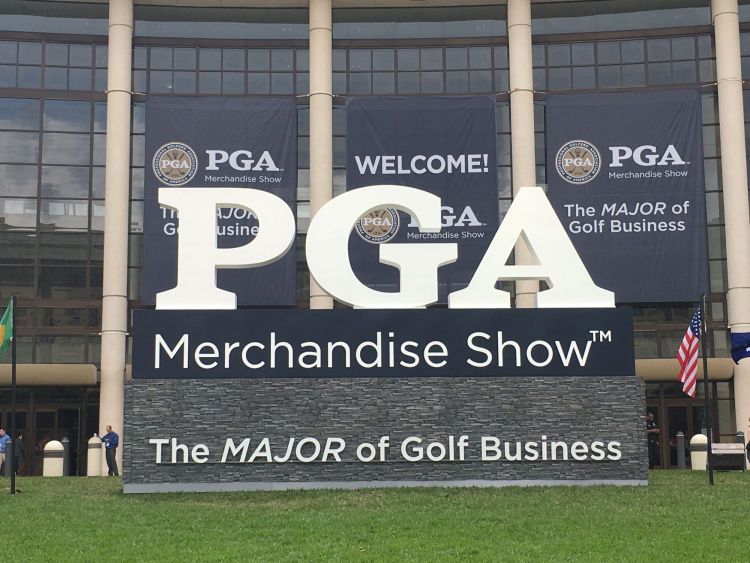 A sign for the pga merchandise show in front of a building