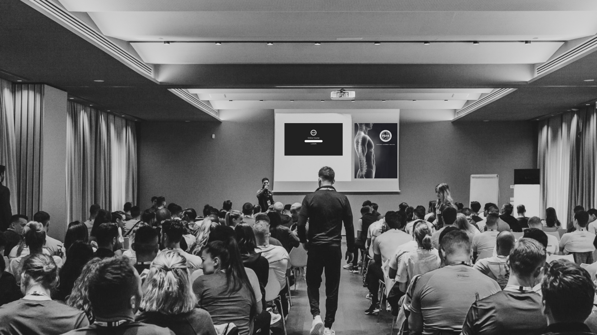 A man is giving a presentation to a large group of people in a conference room.