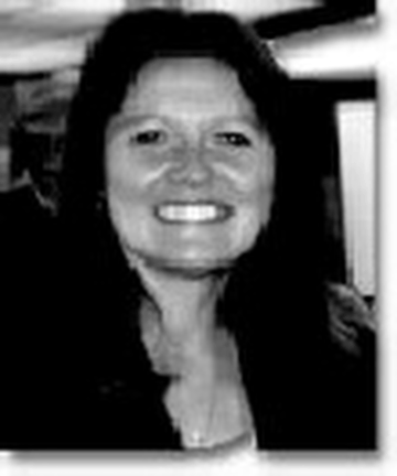 A woman is smiling in a black and white photo.