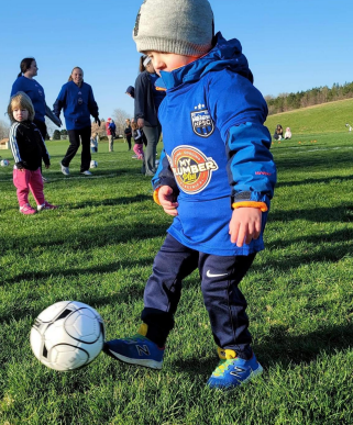 Young child kicking a ball for Northern Piedmont Sports Club