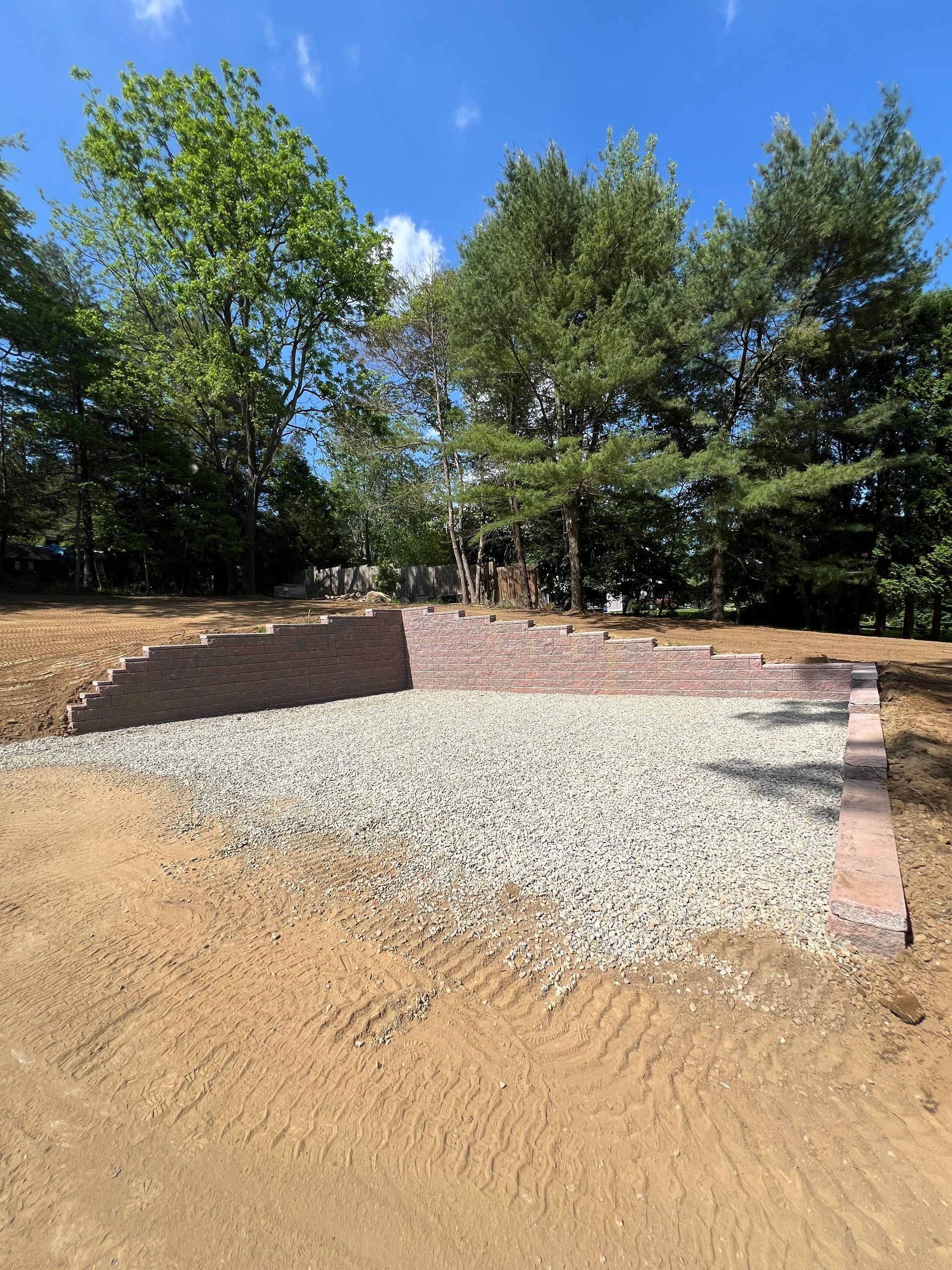 Gravel pad with tiered retaining wall