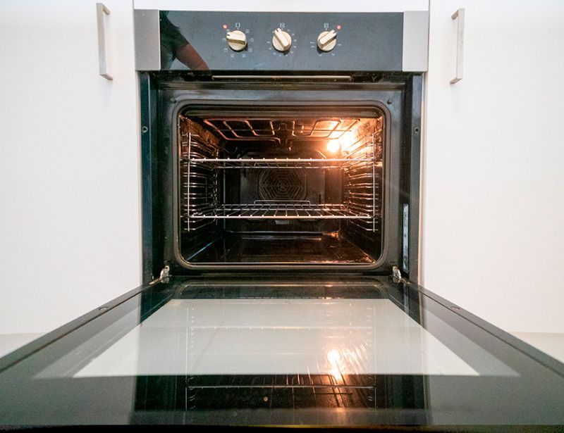 Oven interior with glass door open and bright light inside