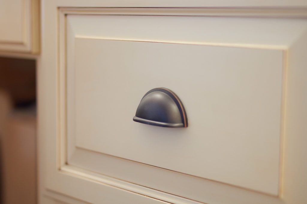 a close up of a white drawer with a black handle .