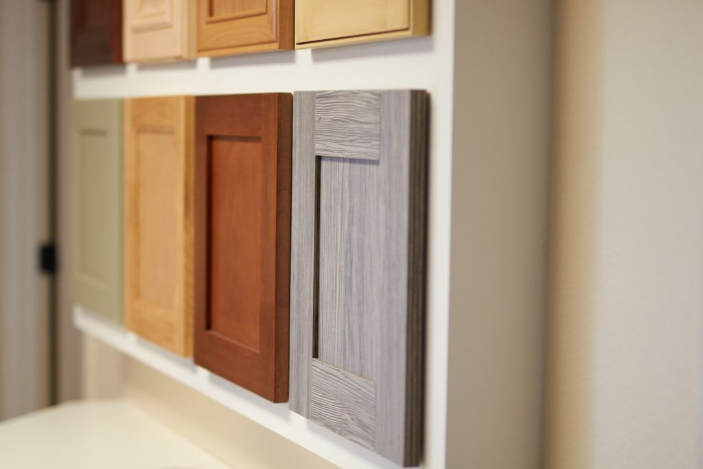 a shelf filled with different types of wooden cabinet doors .