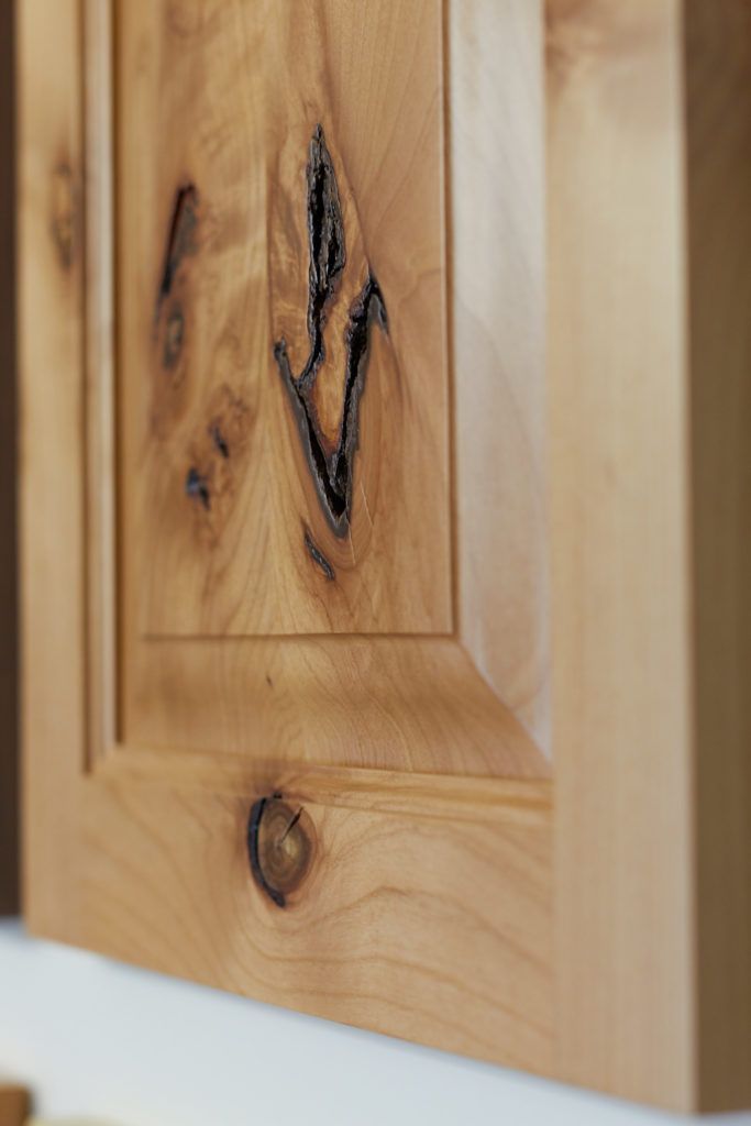 a close up of a wooden cabinet door with a hole in it .