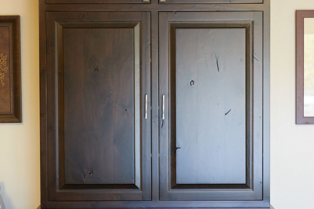 a close up of a wooden cabinet with two doors in a room .