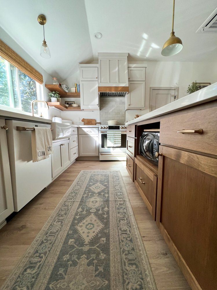 a kitchen with wooden cabinets and a rug on the floor .