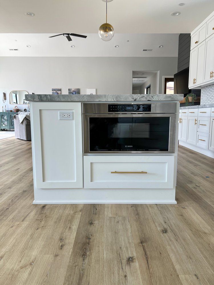 there is a microwave oven in the middle of the kitchen .