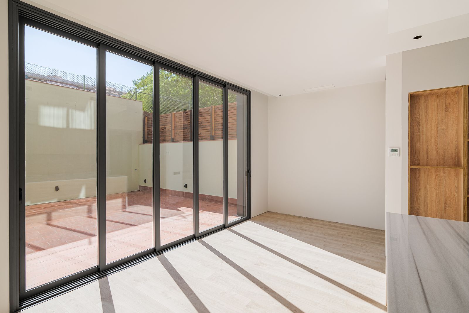 An empty room with a lot of windows and a wooden door.