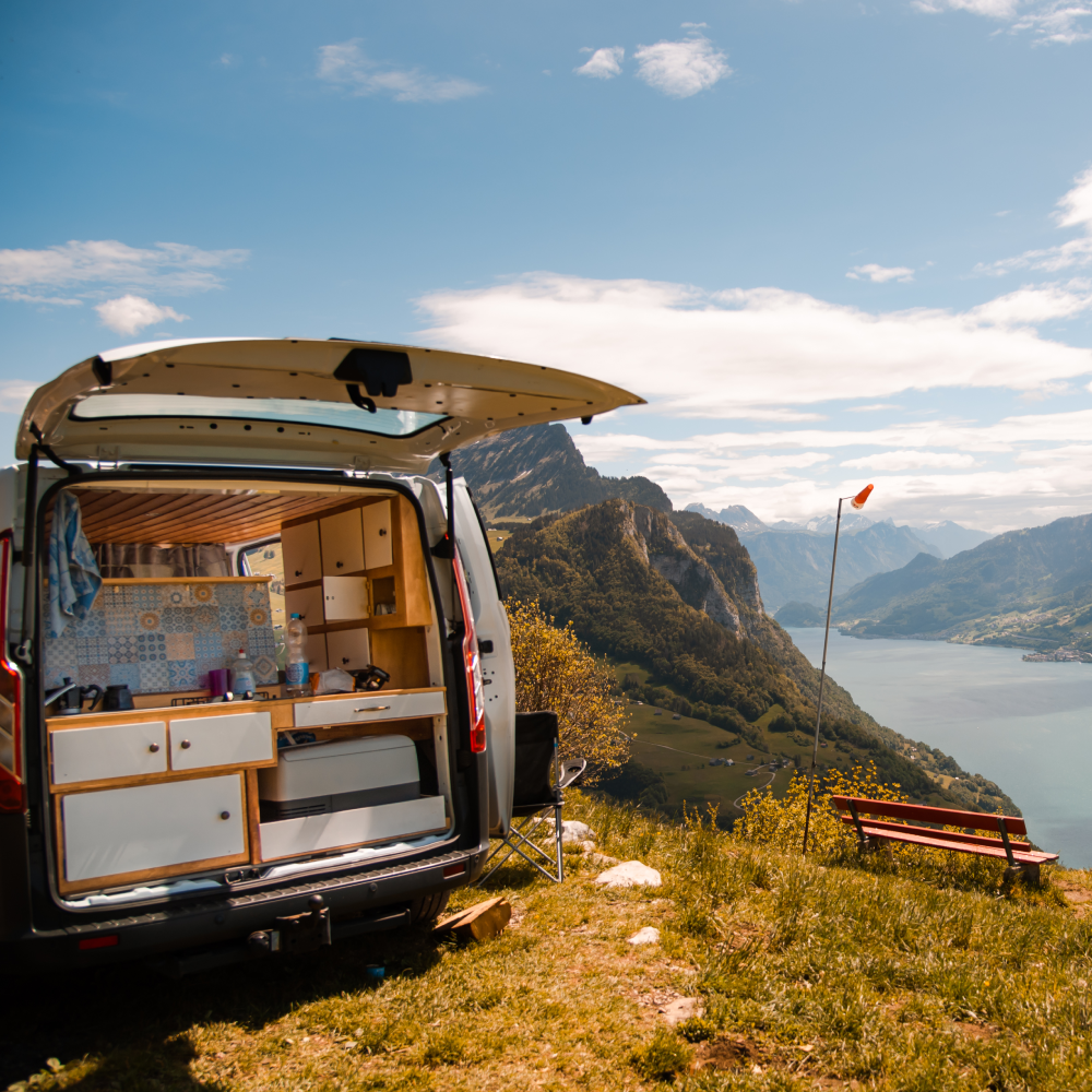 A van is parked on top of a hill with the trunk open