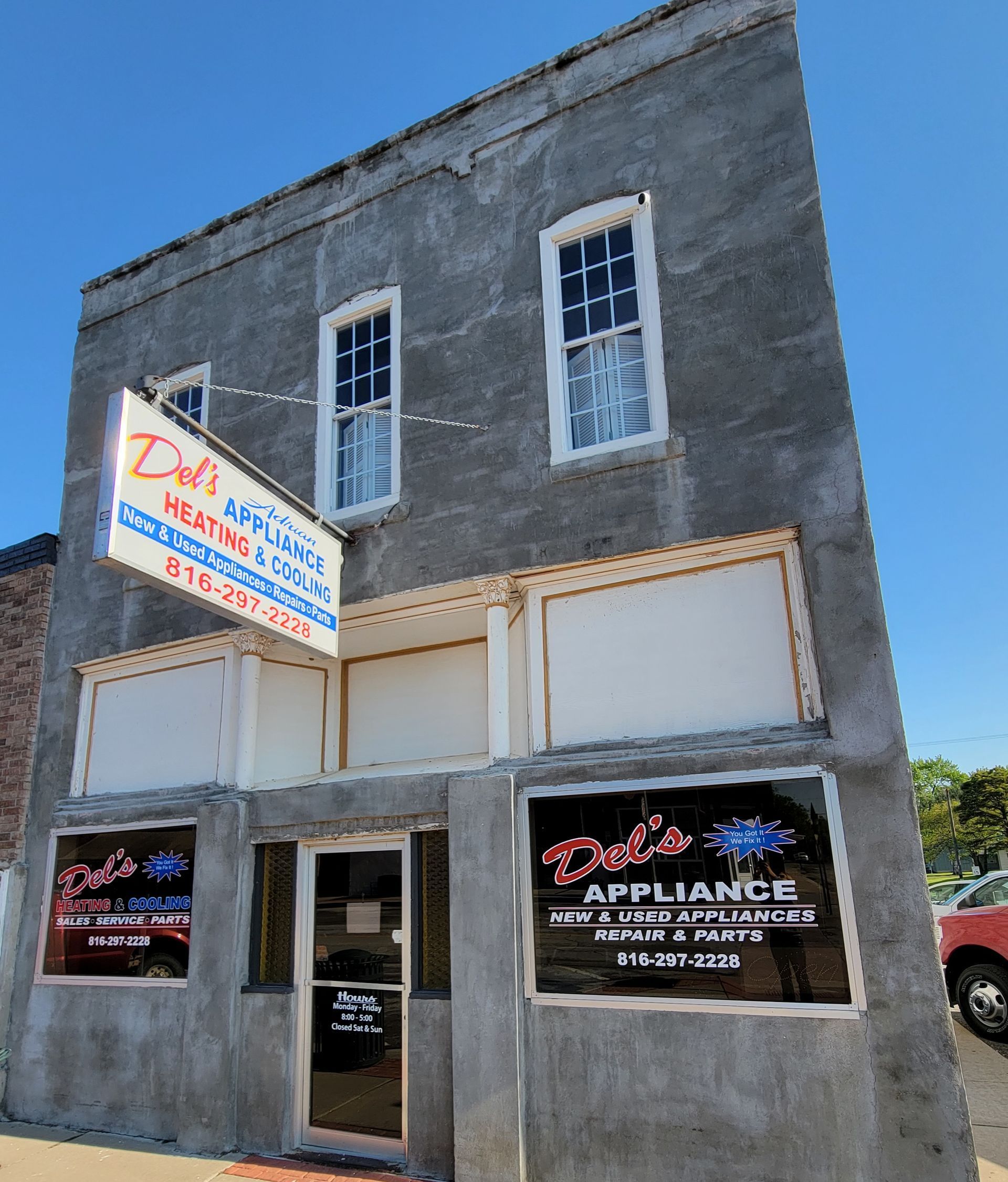 A historic building in Adrian Missouri with a sign that says Del 's appliance repair