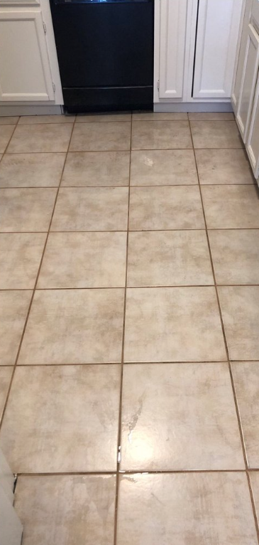 Beige carpet with several light-colored stains near a white baseboard