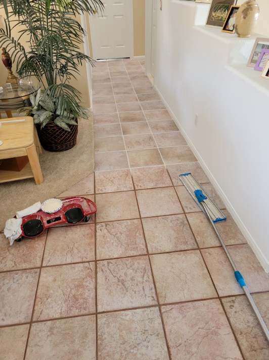 Hallway with tiled floor, a potted plant, and toys scattered along the wall.