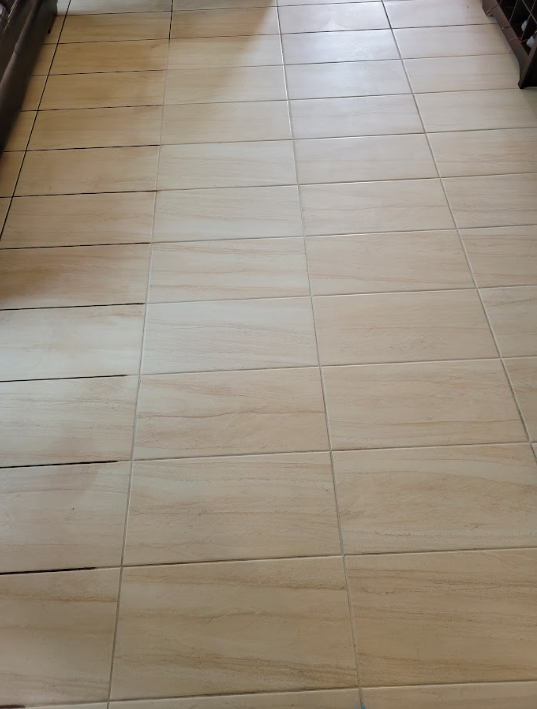 Beige tiled floor hallway with a dark doorway at the far end