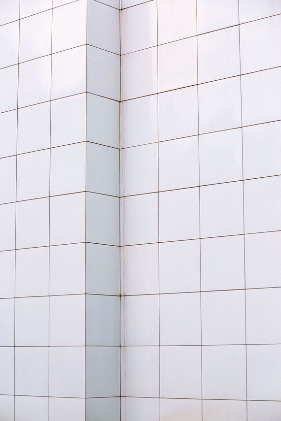 White tiled wall with a vertical seam and dotted grid lines forming a corner.
