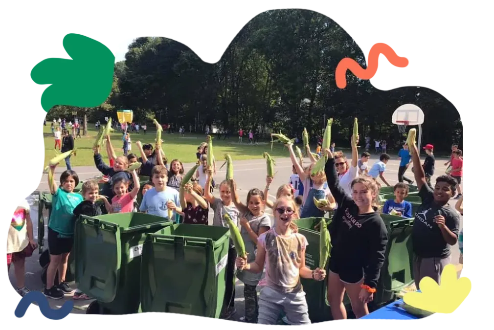 People cheering outdoors near green bins, with raised hands and a basketball hoop in the background.