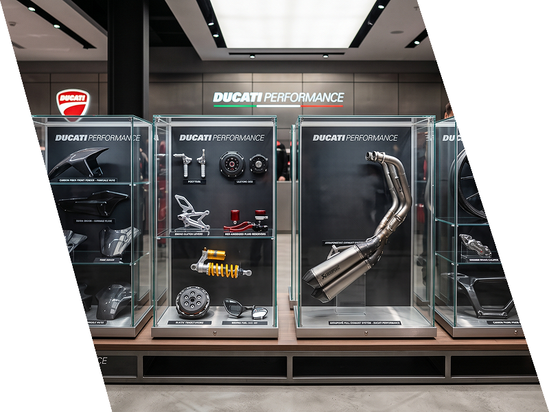 Vitrine da Ducati Performance com peças e acessórios para motocicletas em um showroom.