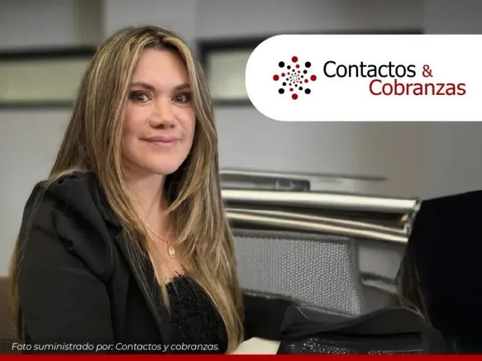 Mujer sentada en un escritorio en una oficina, con el logotipo de 