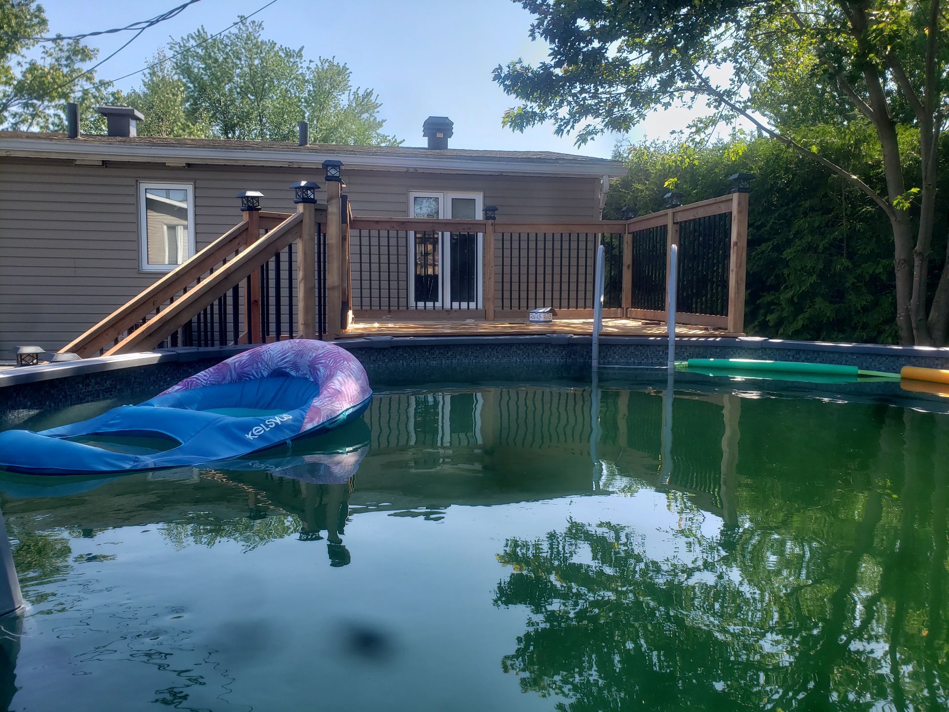 Une grande piscine avec une maison en arrière-plan