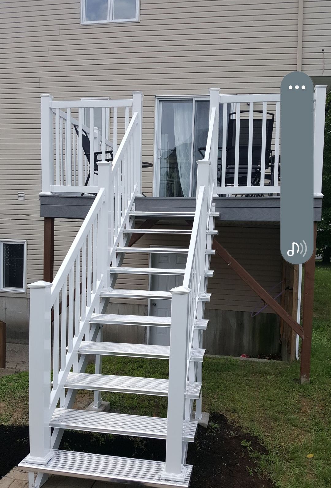 Une terrasse blanche avec des escaliers qui y mènent