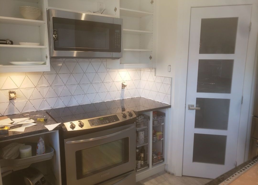 Une cuisine avec une cuisinière, un four et un micro-ondes