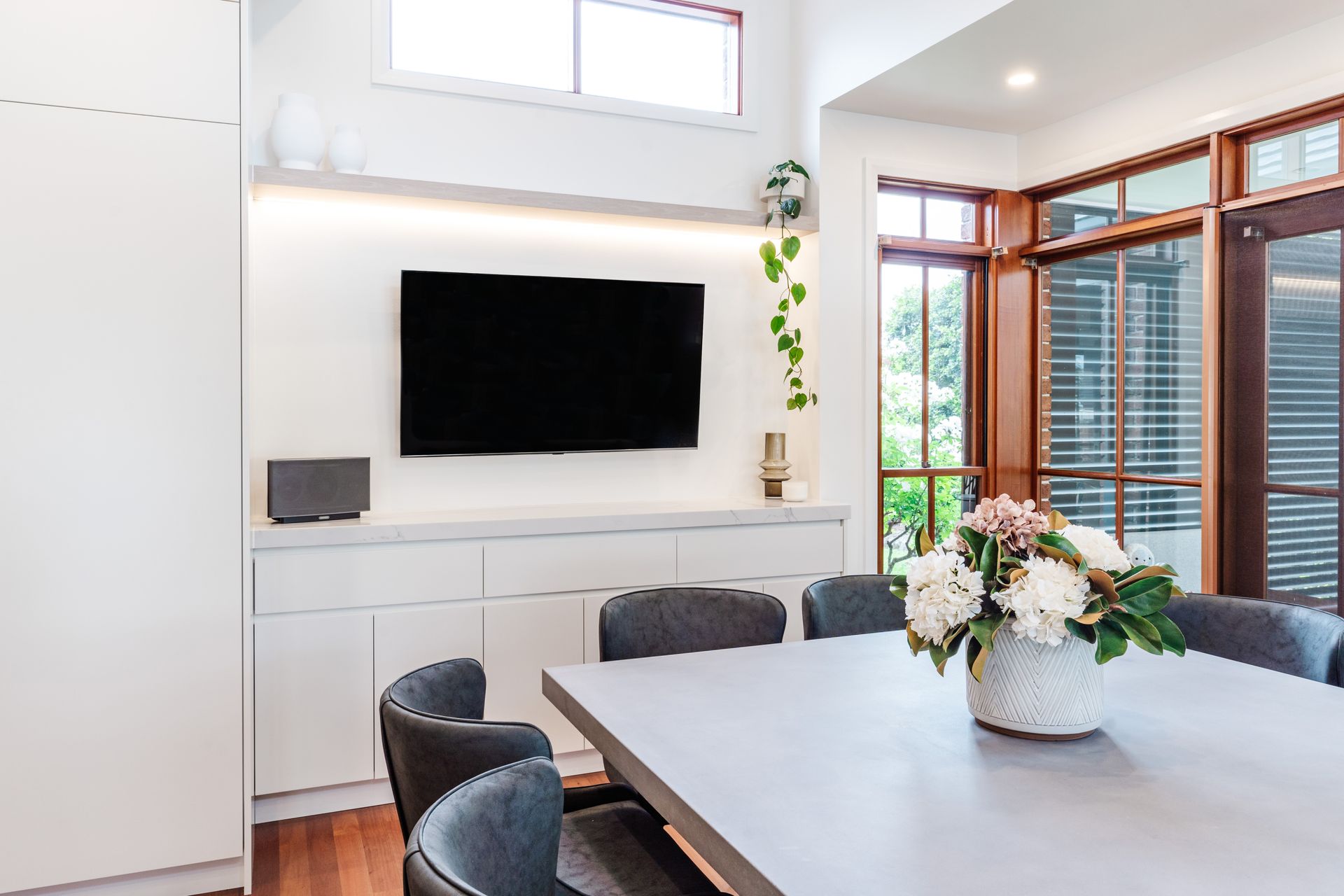 Bright Modern Dining Room With Wall-mounted TV — PKJ Design in Unanderra, NSW
