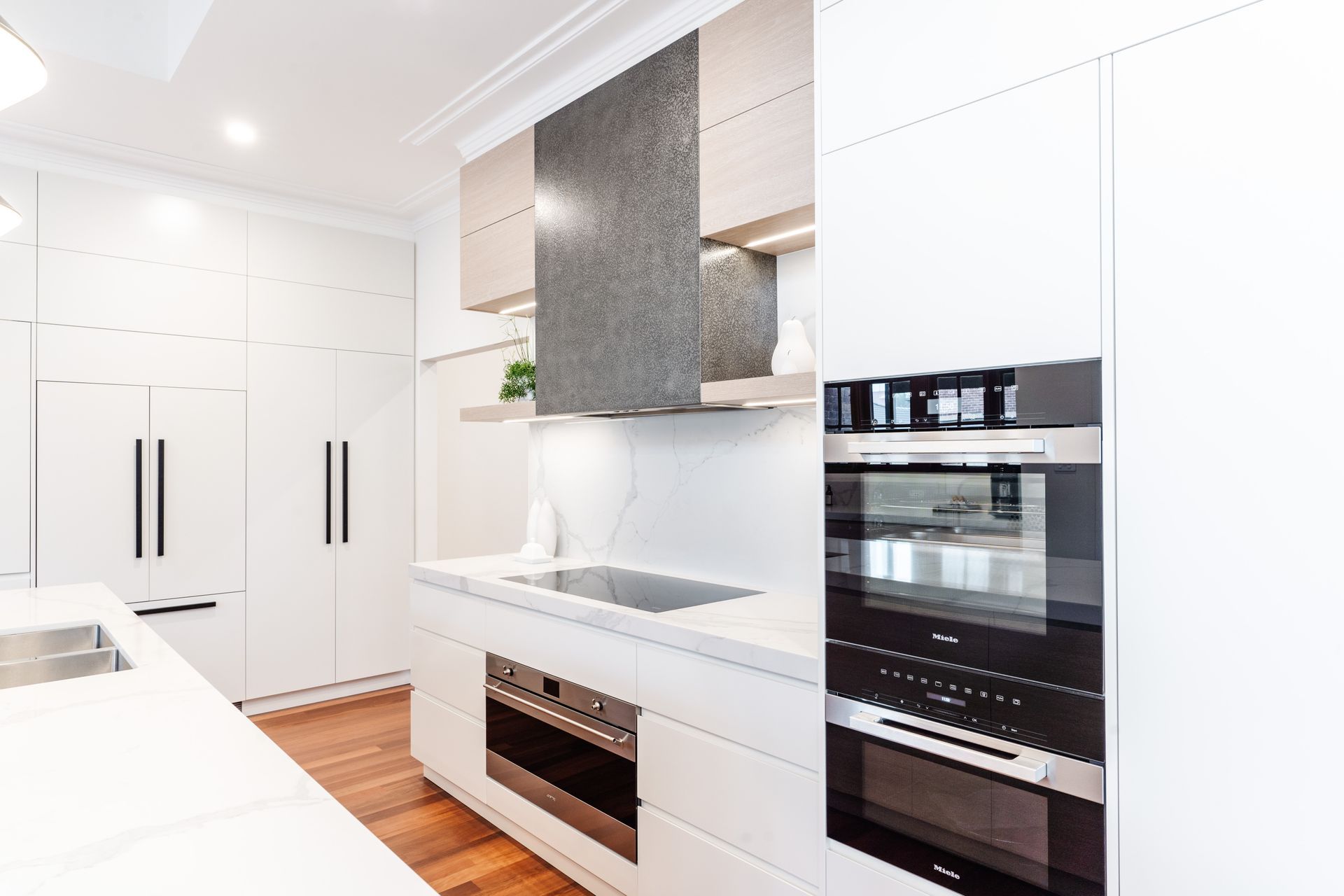 Modern Kitchen With Built-in Ovens, Island, and Stainless Steel Range Hood — PKJ Design in Unanderra, NSW