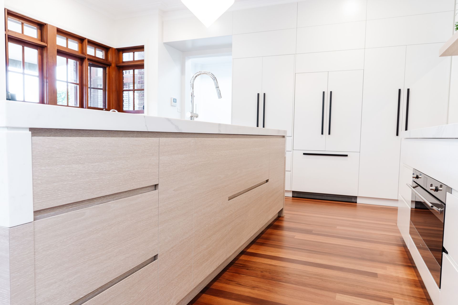 Bright White Modern Kitchen With Wood Floors — PKJ Design in Unanderra, NSW
