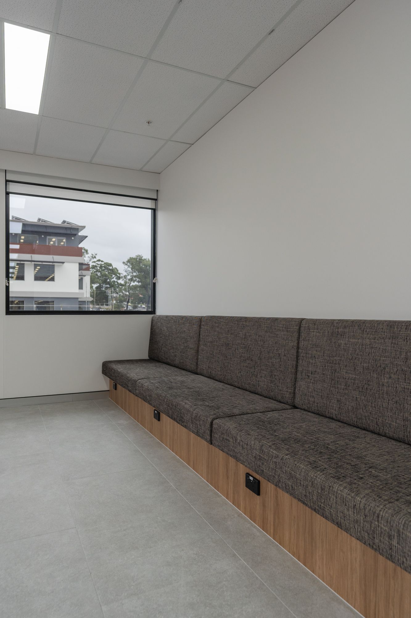 Empty Office Lounge With Gray Built-in Bench Seating — PKJ Design in Unanderra, NSW