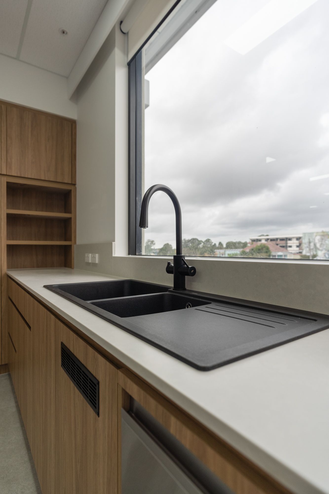 Kitchen Sink by a Large Window With Wood Cabinets — PKJ Design in Unanderra, NSW