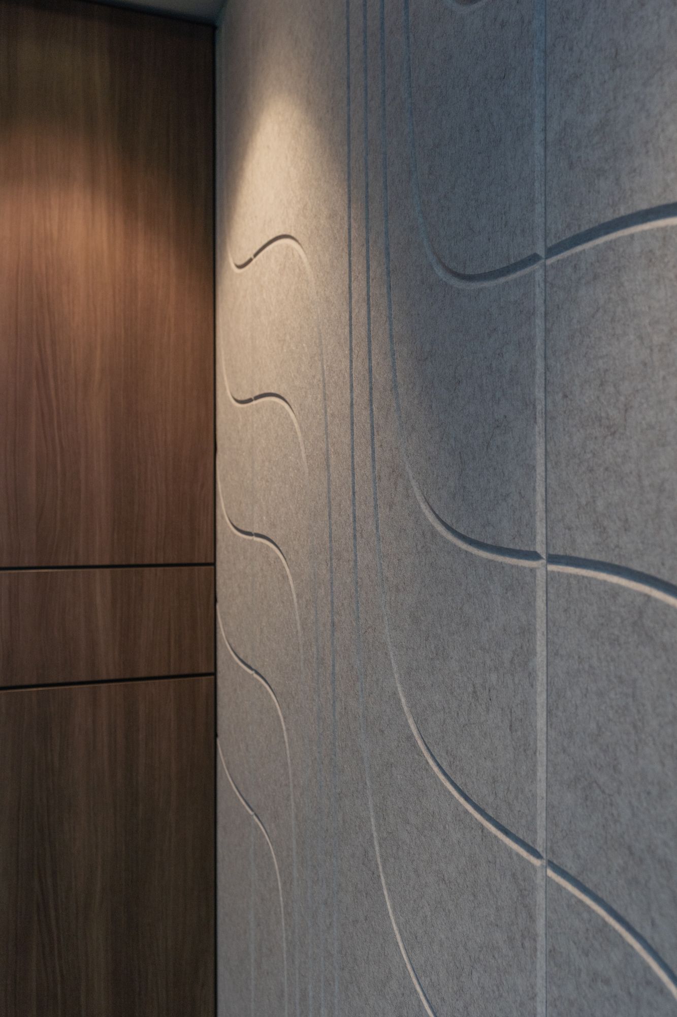 Hallway With Gray Textured Wall Panels and Wood Door Trim — PKJ Design in Unanderra, NSW