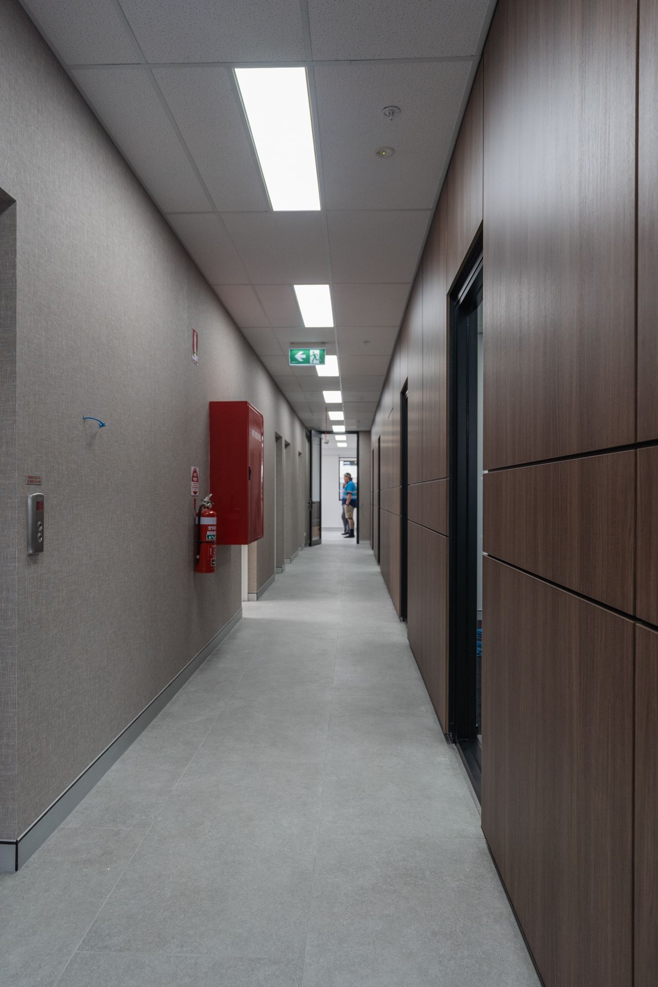Long, Empty Office Hallway With Gray Carpet — PKJ Design in Unanderra, NSW