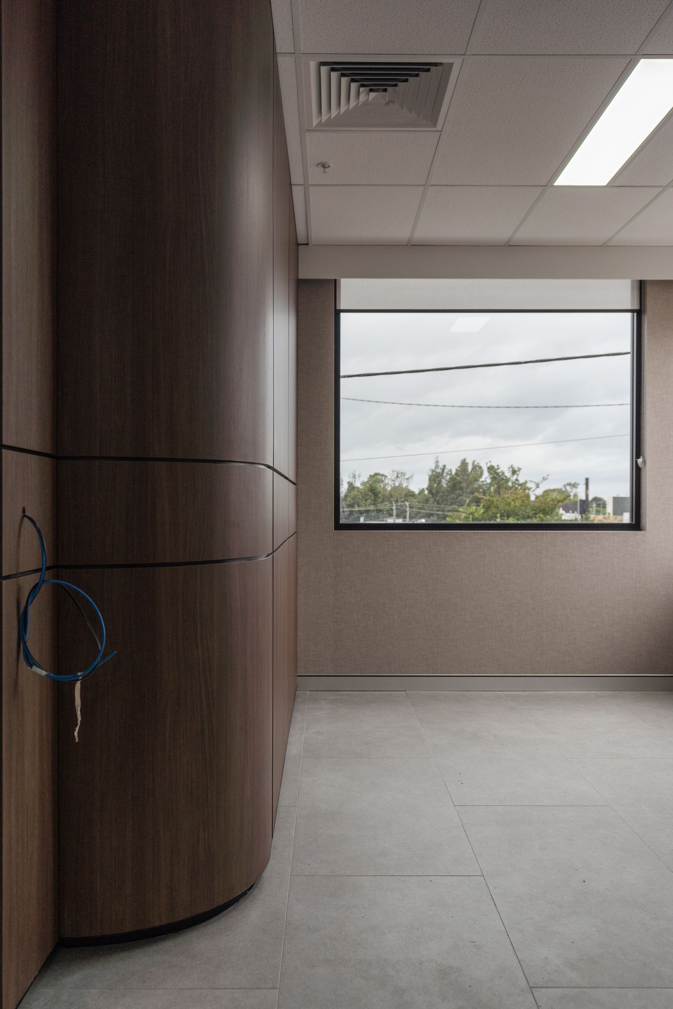 Empty Office Hallway With a Curved Wood Wall — PKJ Design in Unanderra, NSW