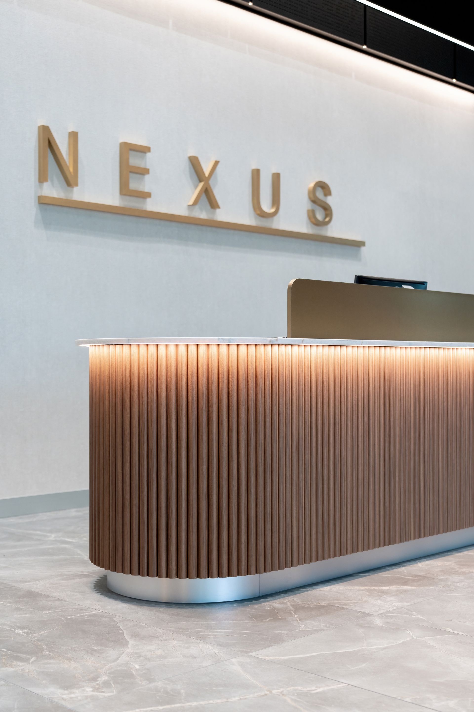 Lobby Reception Desk With Wood Slats and Nexus Sign — PKJ Design in Unanderra, NSW