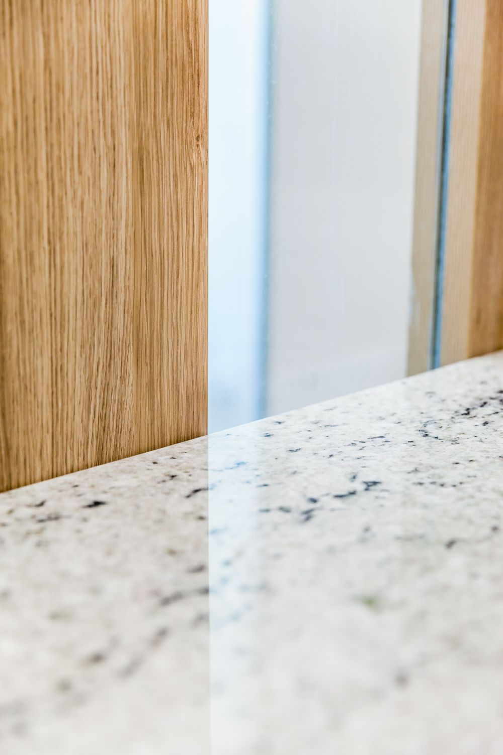 White Granite Countertop Beside Wood-paneled Wall — PKJ Design in Unanderra, NSW