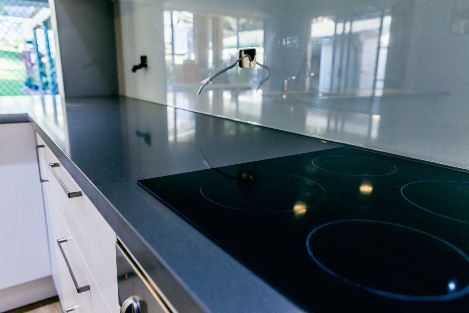 Modern Kitchen With Glossy Black Induction — PKJ Design in Unanderra, NSW