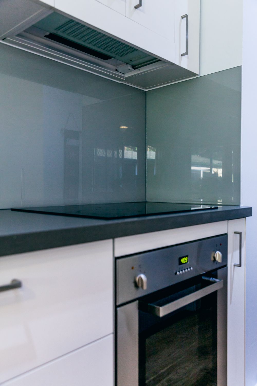 Modern Kitchen With White Cabinets and Black Countertop — PKJ Design in Unanderra, NSW