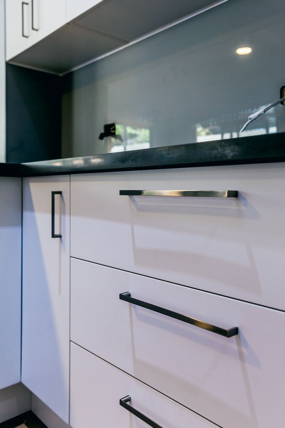Kitchen Cabinets With Black Countertop and Silver Handles — PKJ Design in Unanderra, NSW