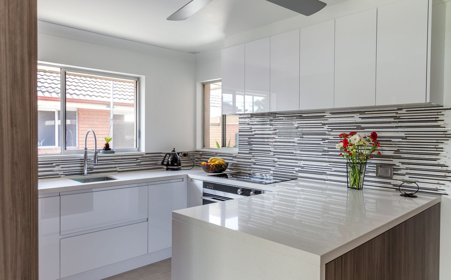 Modern White Kitchen With Striped Tile Backsplash — PKJ Design in Unanderra, NSW