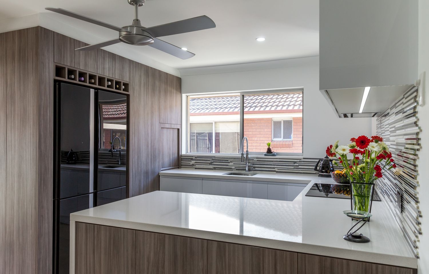 Modern Kitchen With Island, Black Fridge — PKJ Design in Unanderra, NSW