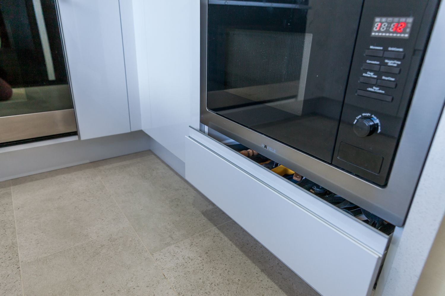 Built-in Microwave Above a Partially Open White Drawer — PKJ Design in Unanderra, NSW