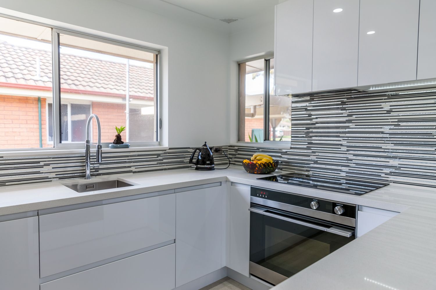 Modern White Kitchen With Gray Backsplash — PKJ Design in Unanderra, NSW