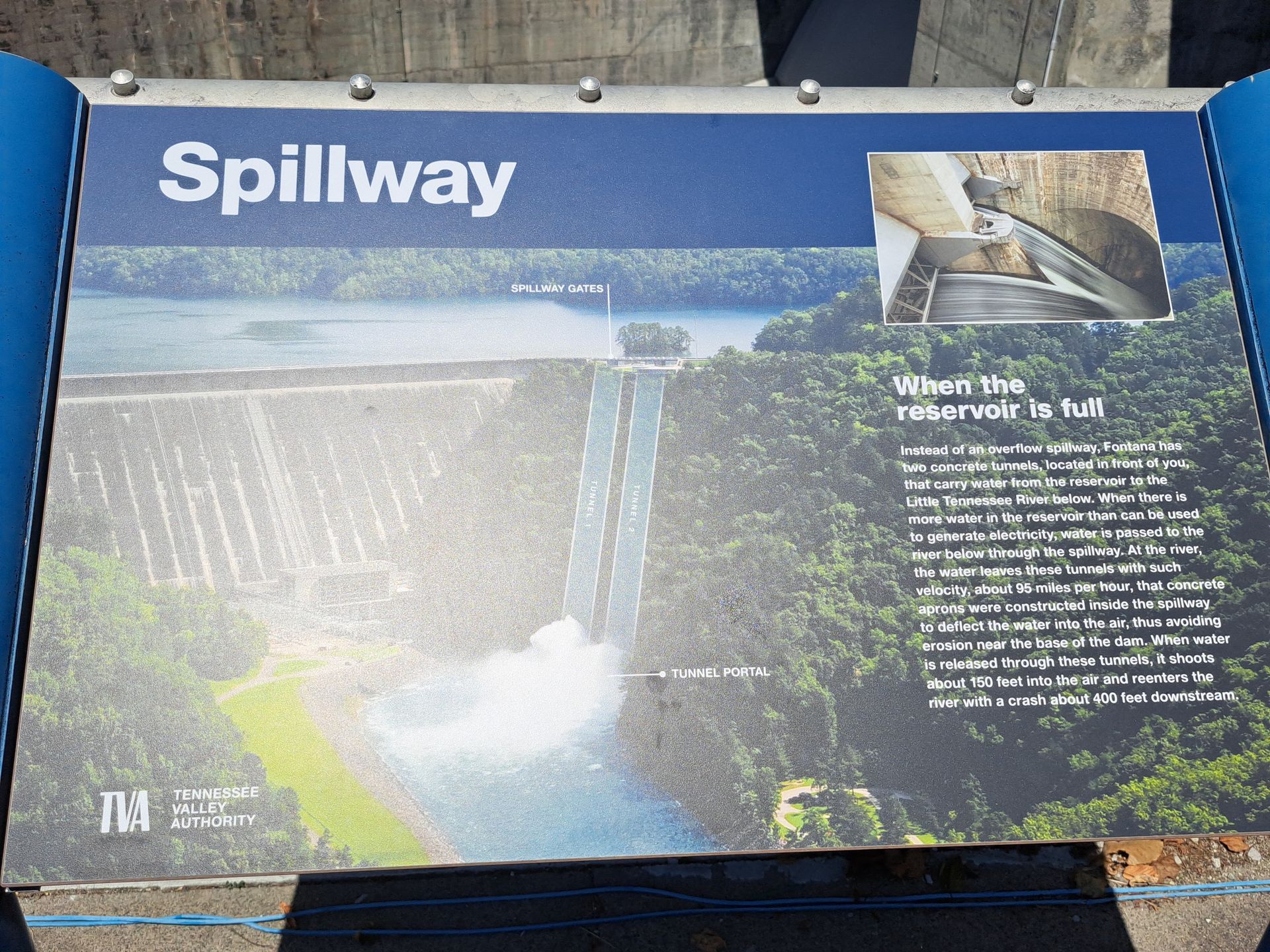 A sign for spillway shows an aerial view of a dam