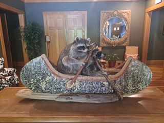 Two raccoons sitting in a canoe artwork